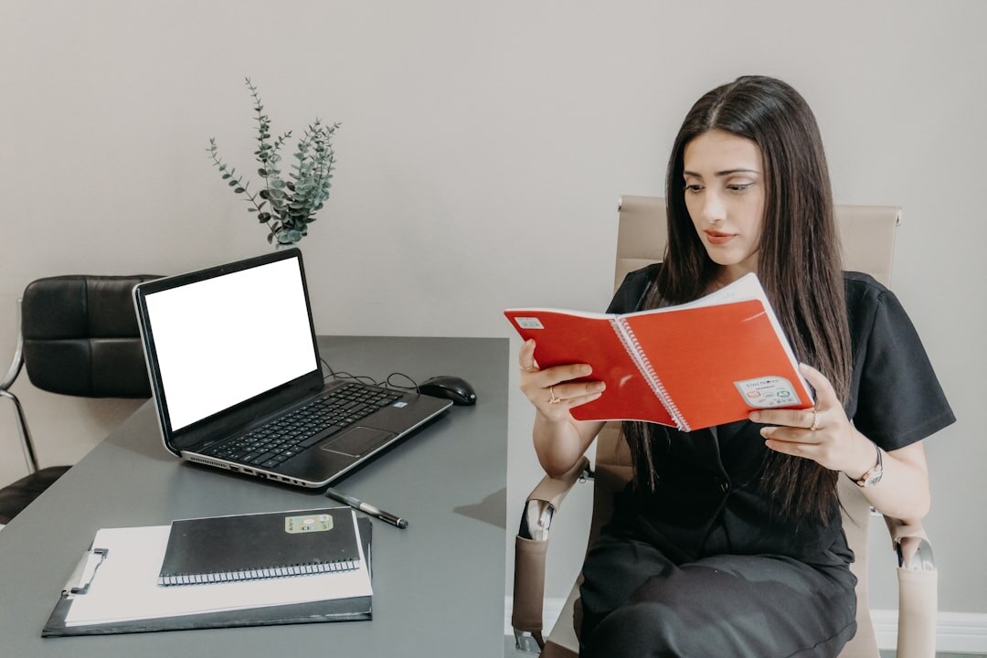 Journalist researching on laptop with notebooks and documents
